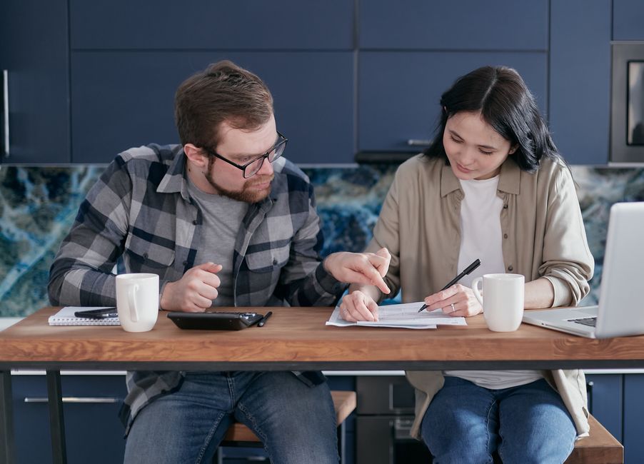 Mid adult couple reviewing bills and managing finances at home.