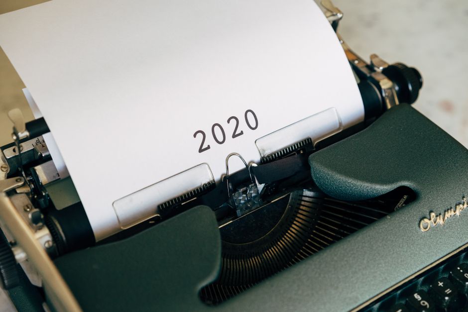 Close-up of a vintage typewriter with the year 2020 typed on paper, symbolizing writing and history.