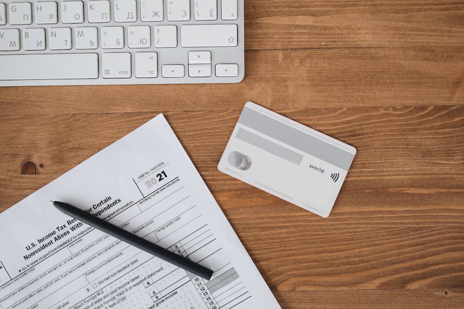 Overhead view of a desk with tax form, pen, keyboard, and contactless card.